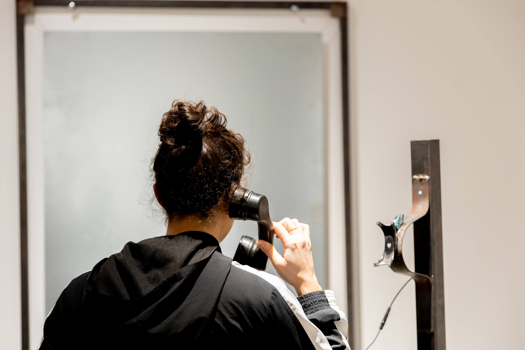 Phone on a metal pole with a red light ontop of it